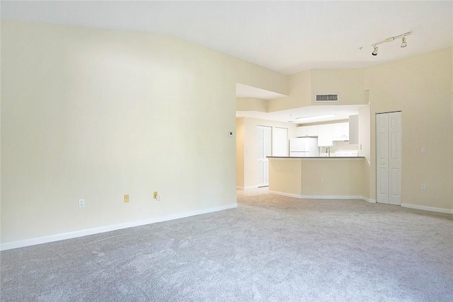 5060 Fairways Cir Unit F312, Vero Beach, FL 32967 - unfurnished living room featuring light colored carpet, baseboards, and track lighting