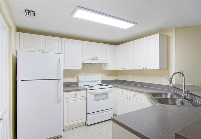 kitchen featuring white appliances, sink, light tile patterned floors, white cabinetry, and kitchen peninsula