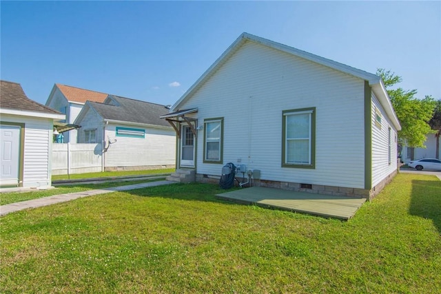 back of property featuring crawl space, a lawn, entry steps, and fence