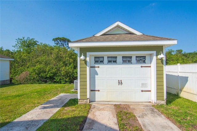 garage with fence and driveway