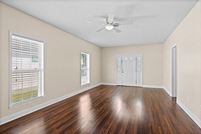 unfurnished room featuring a ceiling fan, baseboards, and dark wood-style flooring