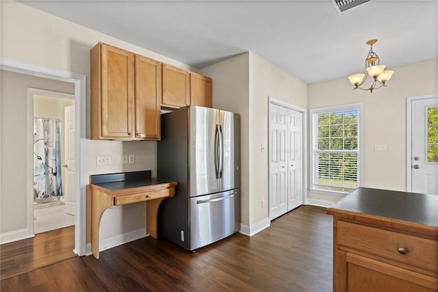 kitchen featuring dark wood-style floors, baseboards, freestanding refrigerator, pendant lighting, and dark countertops