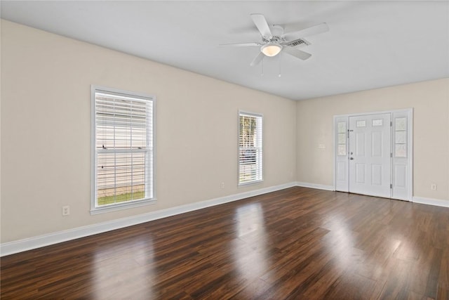 spare room with baseboards, dark wood-type flooring, and ceiling fan