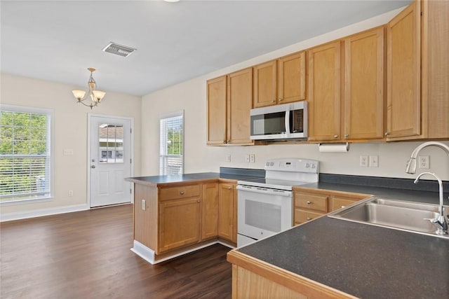 kitchen featuring visible vents, white range with electric cooktop, a sink, dark countertops, and a peninsula