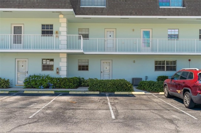 view of property featuring cooling unit and uncovered parking