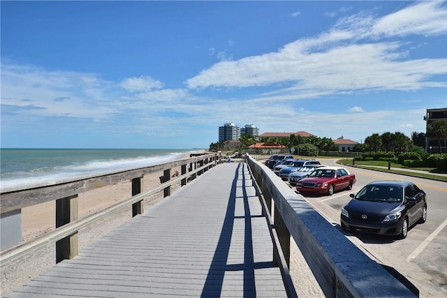 dock area featuring a beach view and a water view