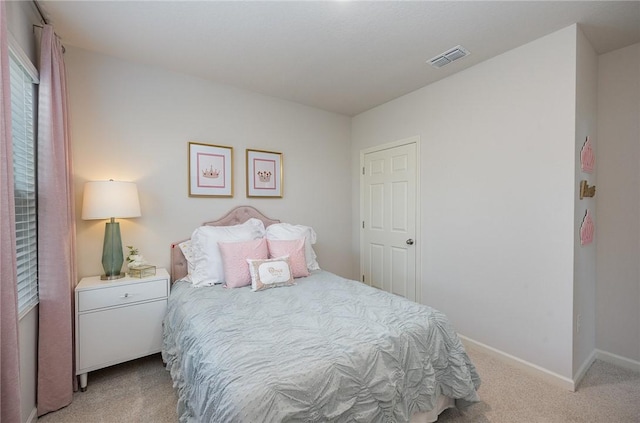 bedroom featuring baseboards, visible vents, and light carpet