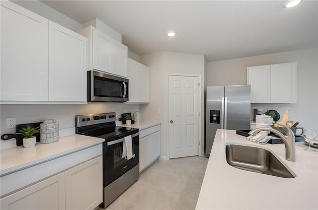 kitchen with a sink, light countertops, white cabinetry, and stainless steel appliances