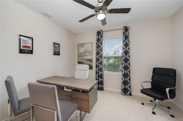 home office with light carpet, visible vents, ceiling fan, and baseboards