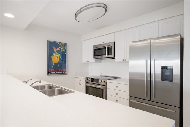 kitchen featuring stainless steel appliances, white cabinetry, and sink