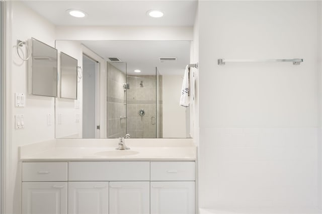 bathroom with vanity and a shower with door