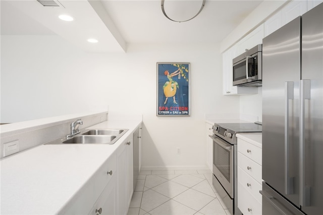 kitchen featuring white cabinetry, appliances with stainless steel finishes, sink, and light tile patterned flooring