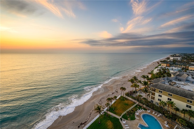 aerial view at dusk with a beach view and a water view