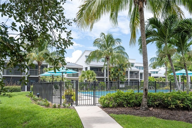 view of home's community with a pool and a yard