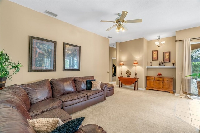 carpeted living room with ceiling fan with notable chandelier