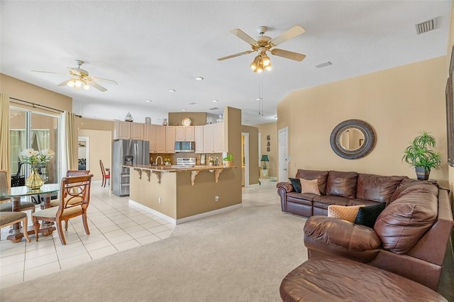 tiled living room with sink and ceiling fan