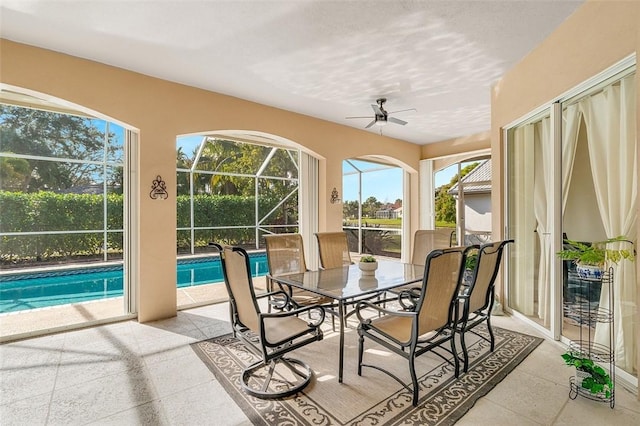 sunroom / solarium with ceiling fan and a swimming pool