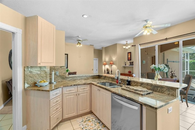 kitchen with light stone countertops, stainless steel dishwasher, sink, kitchen peninsula, and light tile patterned flooring