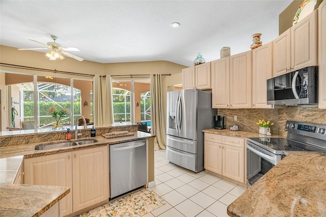 kitchen featuring stainless steel appliances, decorative backsplash, sink, light tile patterned flooring, and ceiling fan