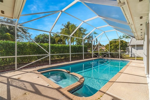 view of swimming pool with glass enclosure, a pool with connected hot tub, and a patio