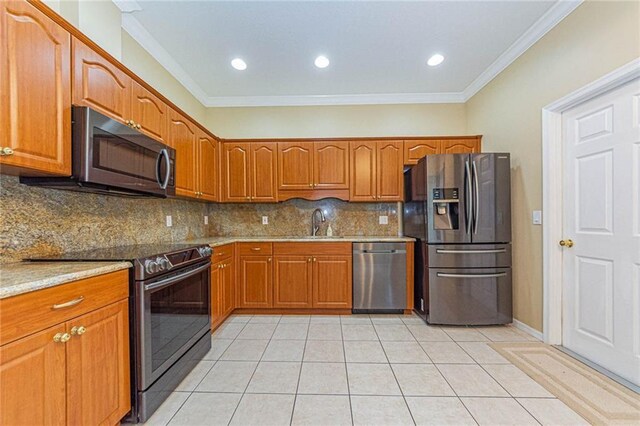 7941 Cabot Tower Pl, Vero Beach, FL 32966 - kitchen with stainless steel appliances, ornamental molding, backsplash, and brown cabinetry