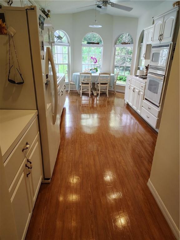 3932 58th Cir, Vero Beach, FL 32966 - kitchen featuring white appliances, wood finished floors, healthy amount of natural light, and ceiling fan