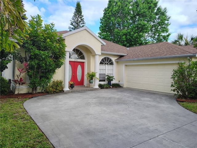 3932 58th Cir, Vero Beach, FL 32966 - view of front of house with concrete driveway, an attached garage, stucco siding, and roof with shingles