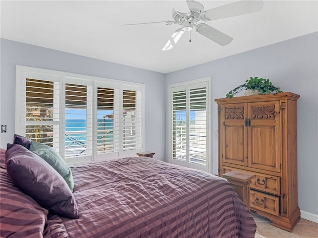 tiled bedroom featuring ceiling fan and multiple windows