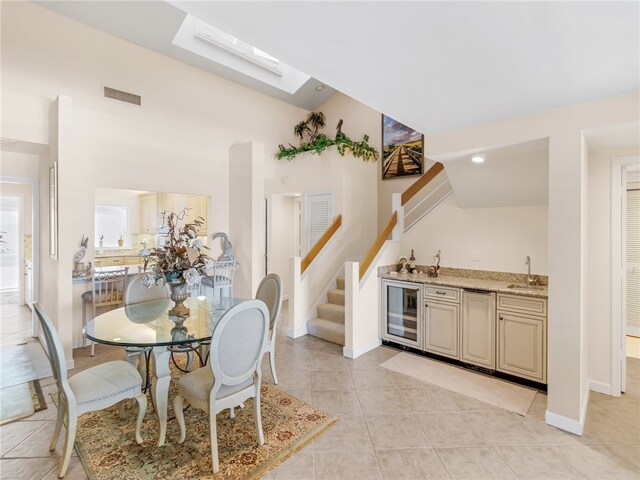 8444 Oceanside Dr Unit D31, Indian River Shores, FL 32963 - dining room with wine cooler, wet bar, stairs, light tile patterned floors, and baseboards