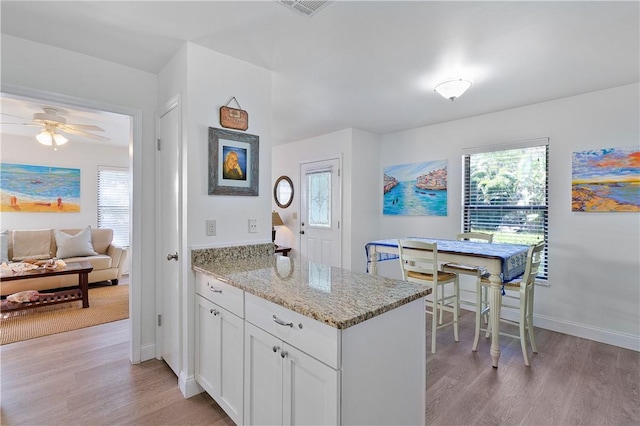 kitchen featuring a healthy amount of sunlight, white cabinetry, and light hardwood / wood-style flooring