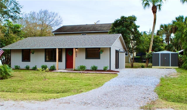 view of front of house with a garage, a front yard, and a storage unit