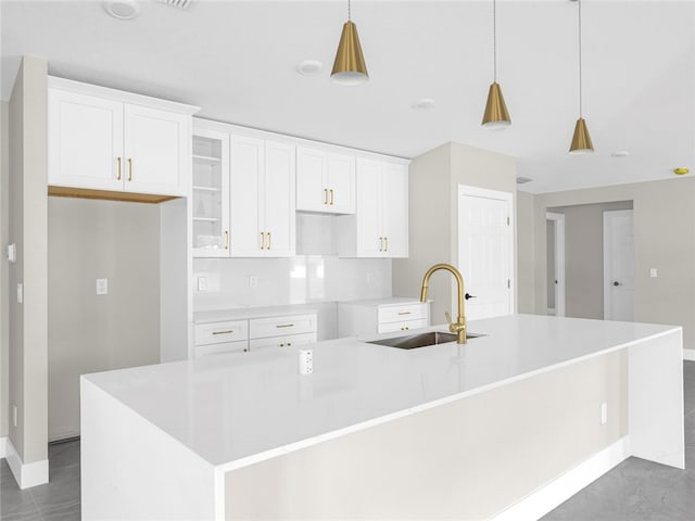 kitchen with a large island with sink, decorative light fixtures, and sink