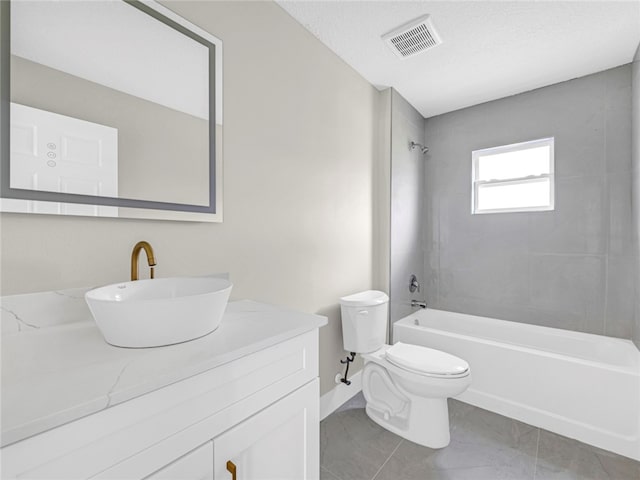 full bathroom with tiled shower / bath combo, toilet, a textured ceiling, and vanity