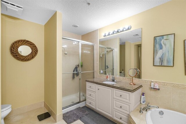 full bathroom featuring tile patterned flooring, vanity, plus walk in shower, a textured ceiling, and toilet