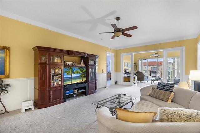 carpeted living room featuring ornamental molding and ceiling fan