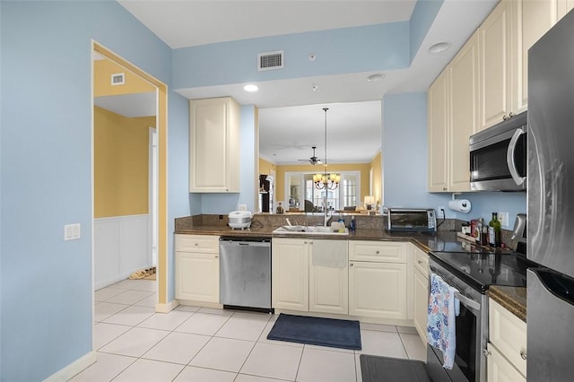 kitchen featuring pendant lighting, sink, light tile patterned floors, appliances with stainless steel finishes, and an inviting chandelier