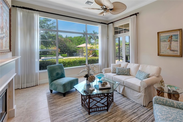 living room with light tile patterned floors, crown molding, and ceiling fan