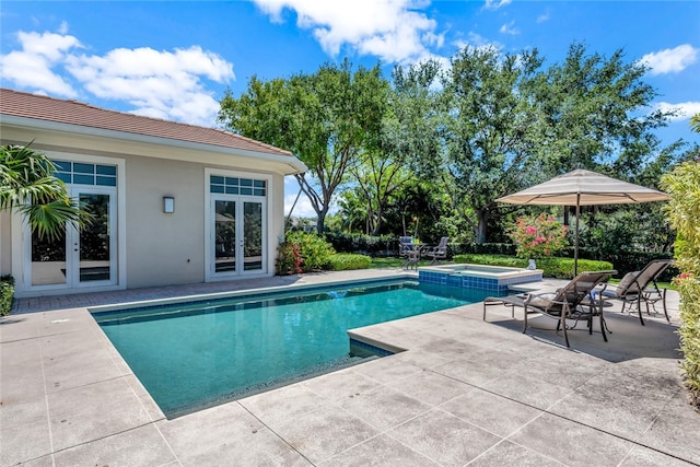 view of pool featuring a patio area and an in ground hot tub