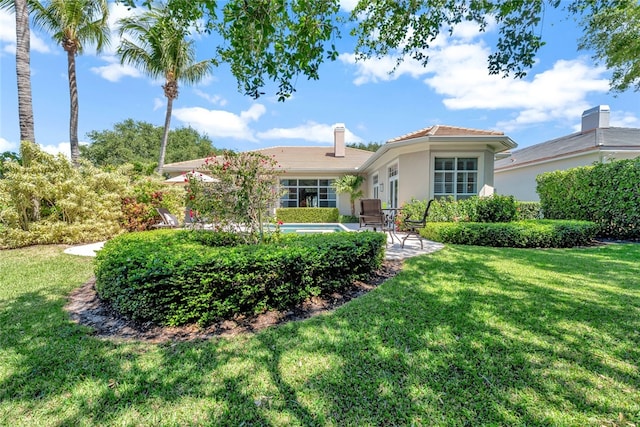 view of front of home with a front yard and a patio area