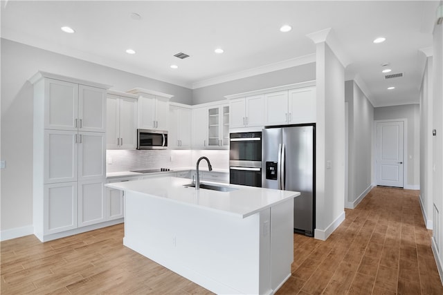 kitchen with white cabinetry, sink, a kitchen island with sink, and appliances with stainless steel finishes