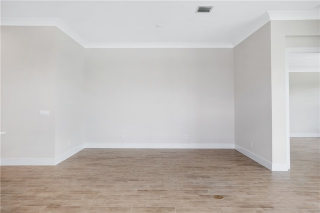 spare room featuring light hardwood / wood-style flooring and crown molding