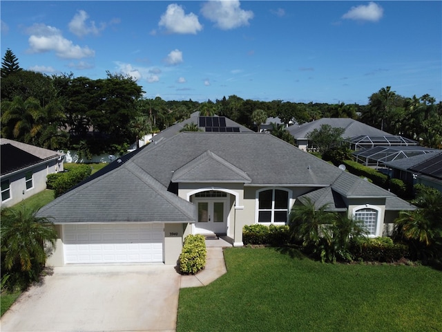 view of front of home featuring a garage, a front lawn, and french doors