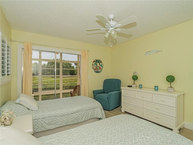 14 Vista Gardens Trl Unit 102, Vero Beach, FL 32962 - bedroom featuring a textured ceiling, a ceiling fan, and light wood finished floors