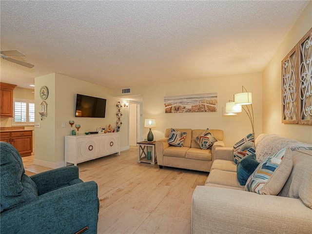 14 Vista Gardens Trl Unit 102, Vero Beach, FL 32962 - living room featuring light wood finished floors, a textured ceiling, and a ceiling fan