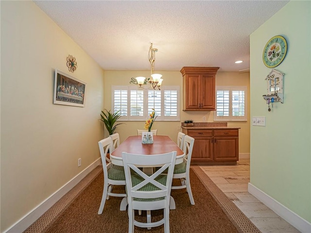 14 Vista Gardens Trl Unit 102, Vero Beach, FL 32962 - dining space with a chandelier, a textured ceiling, baseboards, and recessed lighting