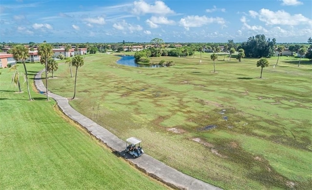 surrounding community with a water view and a lawn