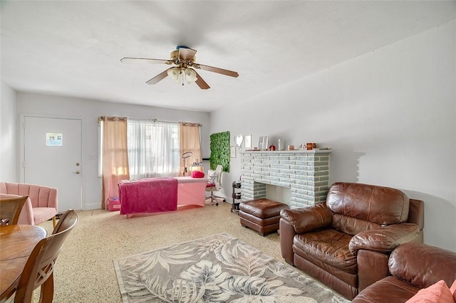 living room featuring ceiling fan and a brick fireplace