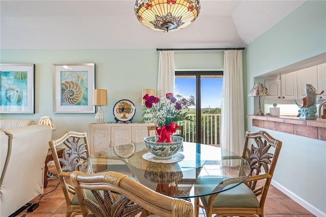 dining space featuring lofted ceiling and light tile patterned flooring