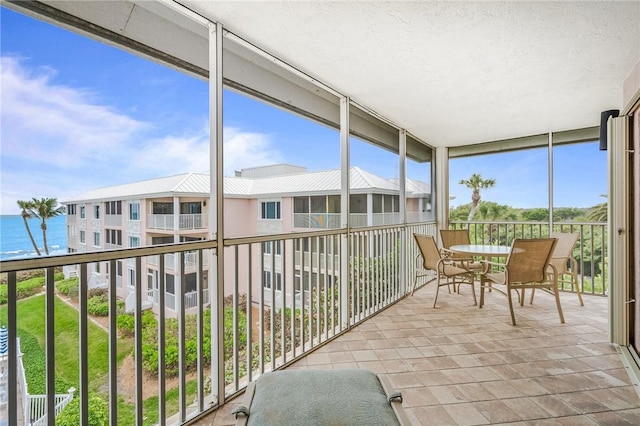 sunroom featuring a water view