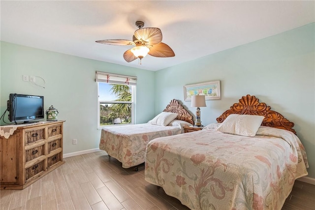 bedroom featuring a ceiling fan, baseboards, and wood finished floors